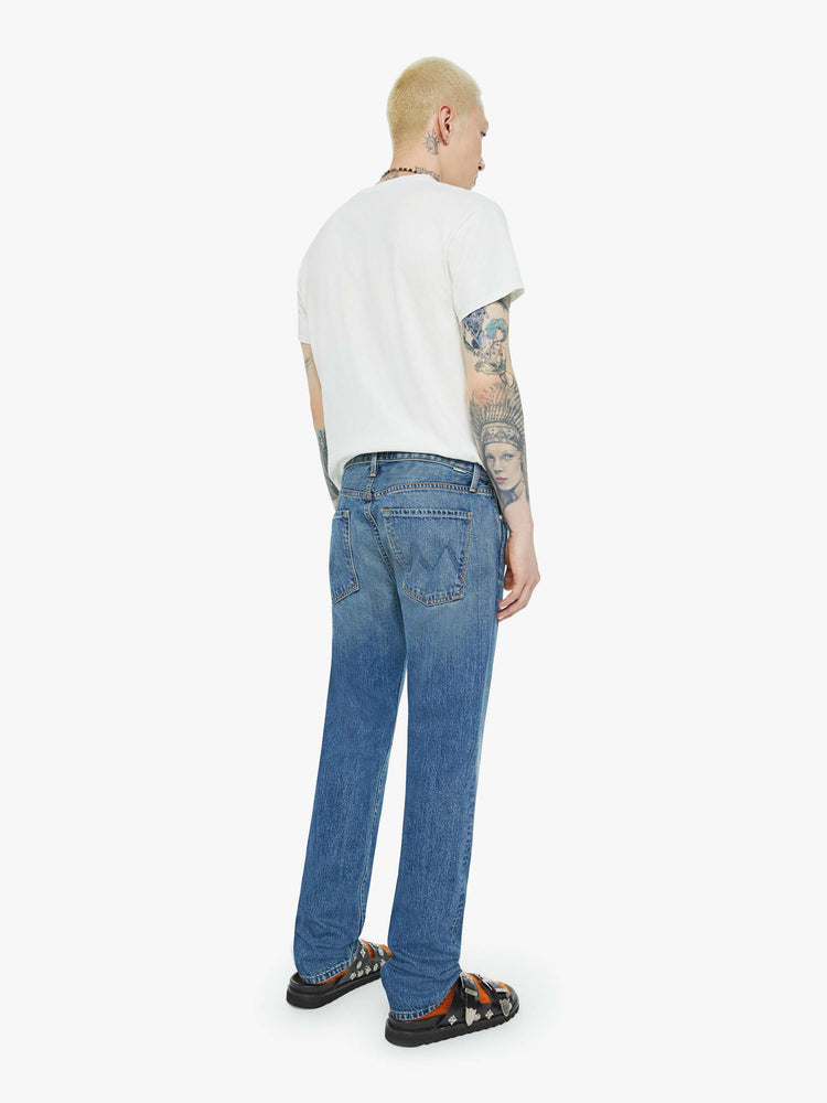 Back view of a man in a slim-straight leg with a mid rise, 32-inch inseam and a clean hem in a mid blue wash.