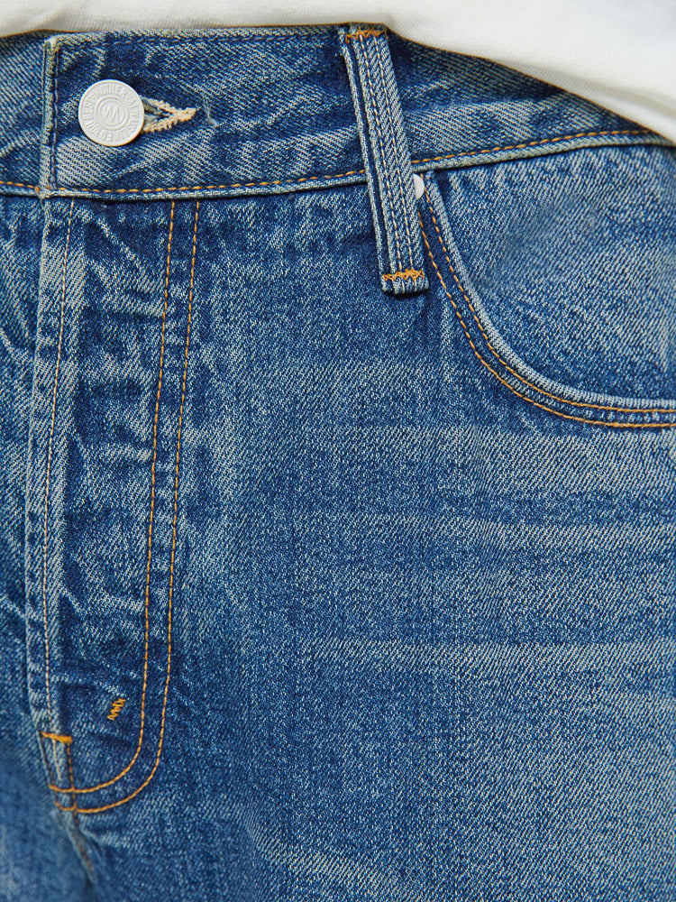 Swatch view of a man in a slim-straight leg with a mid rise, 32-inch inseam and a clean hem in a mid blue wash.