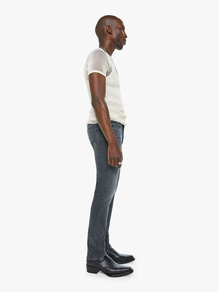 Side view of a man in a slim-straight leg with a mid rise, 32-inch inseam and a clean hem in a faded black wash.