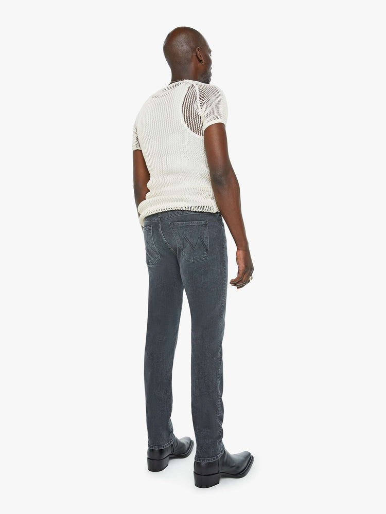 Back view of a man in a slim-straight leg with a mid rise, 32-inch inseam and a clean hem in a faded black wash.