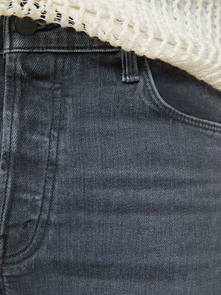 Swatch view of a man in a slim-straight leg with a mid rise, 32-inch inseam and a clean hem in a faded black wash.