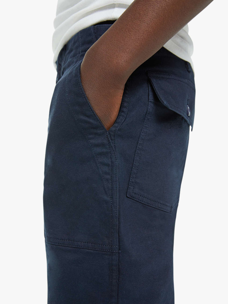 Close up view of a man in an army pant with a slightly dropped crotch, patch pockets and a slim-straight leg in a navy blue wash.