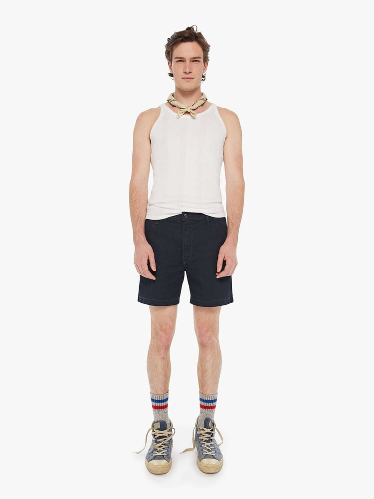 Front view of a man in a navy blue shorts with a mid rise, slit pockets and a 6-inch inseam with a clean hem.