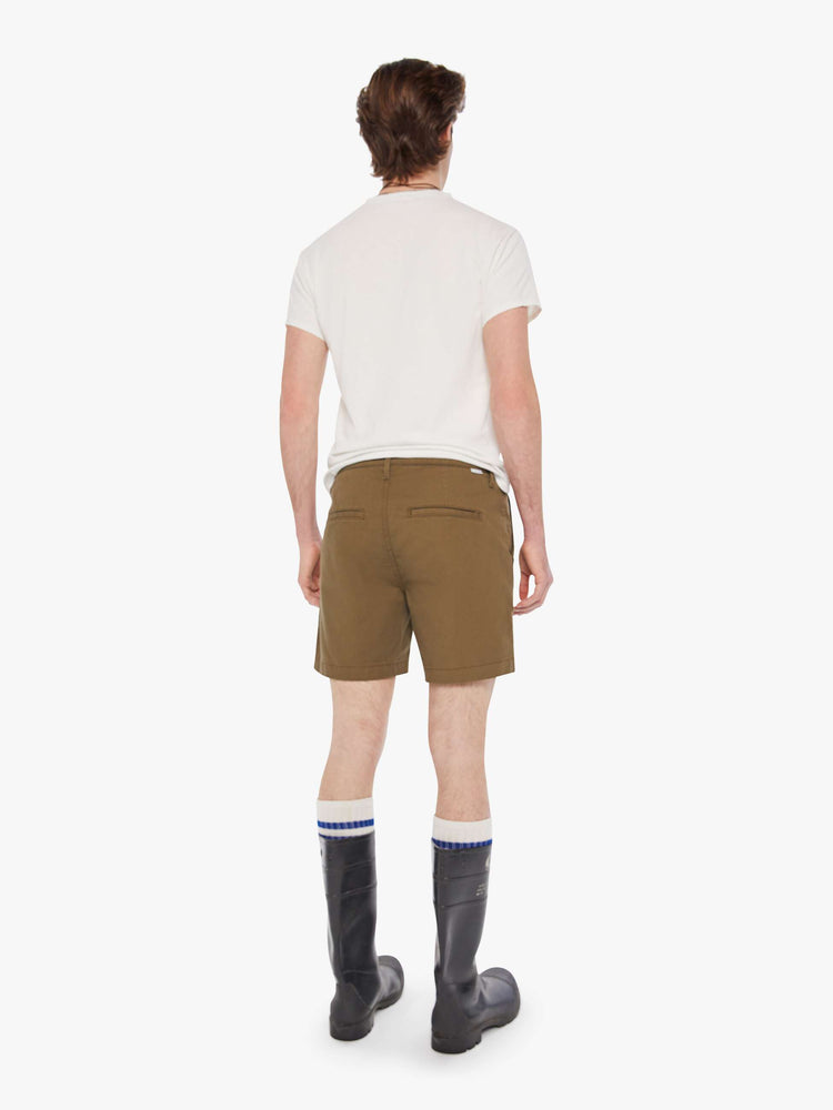 Back view of a man in a military green short with a mid-rise, slit pockets and a 6-inch inseam with a clean hem.