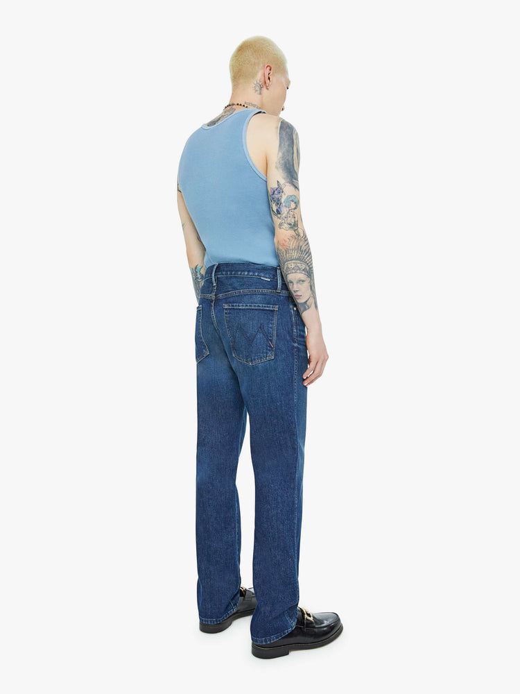 Back view of a man in a straight-leg jean with a mid rise, ankle-length inseam and a clean hem in a dark blue wash.