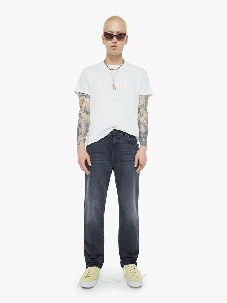 Front view of a man in a dark grey straight-leg jean with a mid rise, zipper fly, 30-inch inseam and a clean hem.