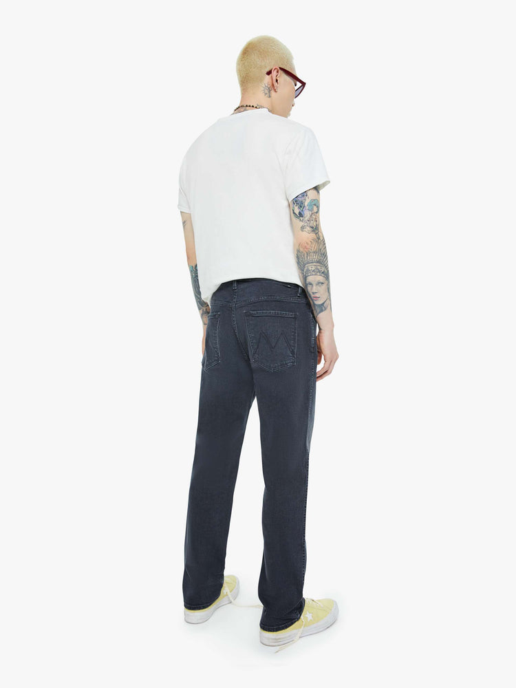 Back view of a man in a dark grey straight-leg jean with a mid rise, zipper fly, 30-inch inseam and a clean hem.