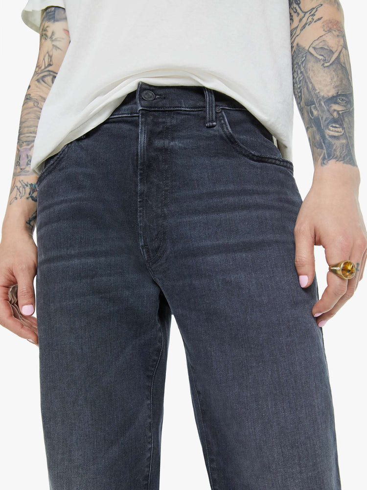 Waist close up view of a man in a dark grey straight-leg jean with a mid rise, zipper fly, 30-inch inseam and a clean hem.