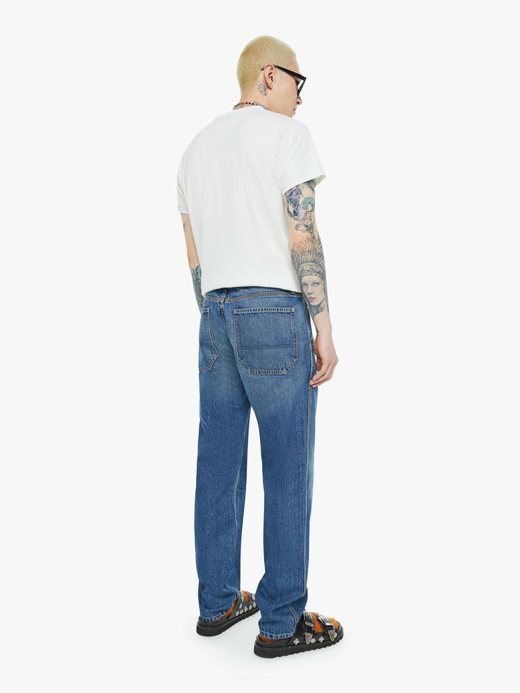 Back view of a man in mid-blue wash classic pant with utilitarian pockets, a hammer loop and relaxed leg.