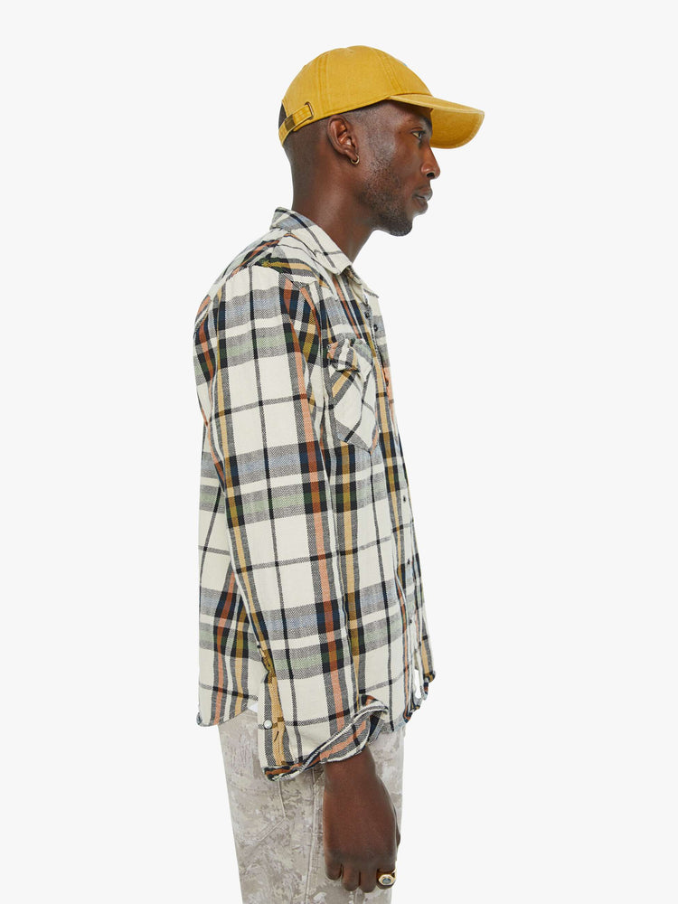 Side  view of a mens plaid print with patch pockets, long sleeves and a curved hem.