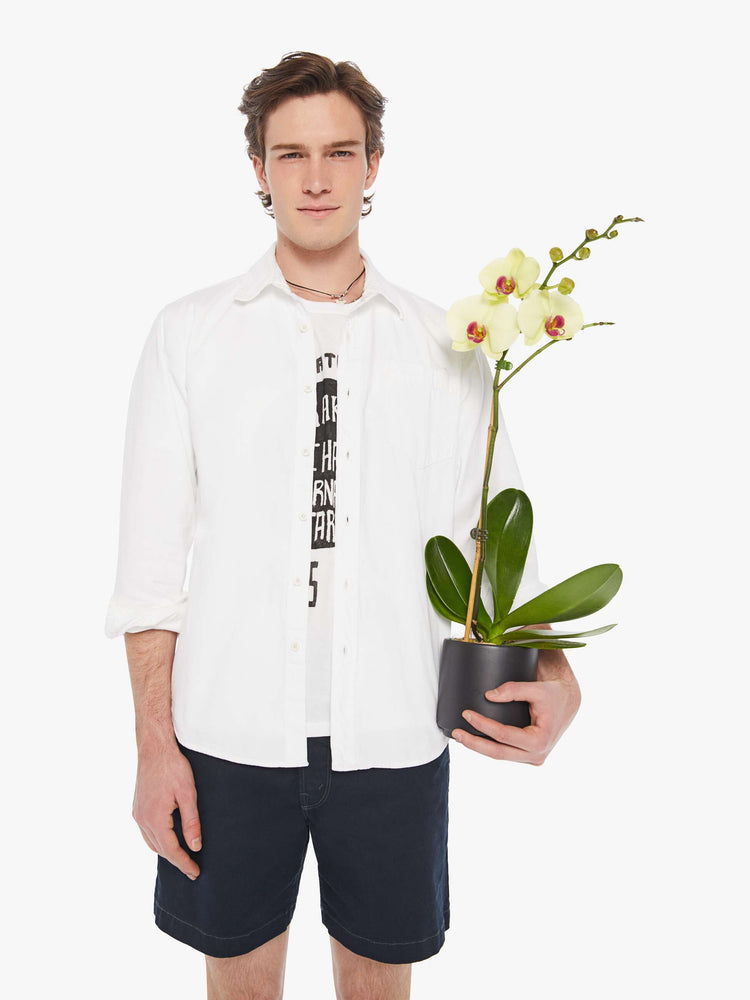 Front view a man in a white collared button-up with a patch pocket and a slightly curved hem.