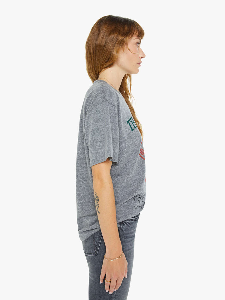 WOMEN side view of a an oversized tee with drop shoulders in a heathered grey with a faded feck of cards with text in green in the front.