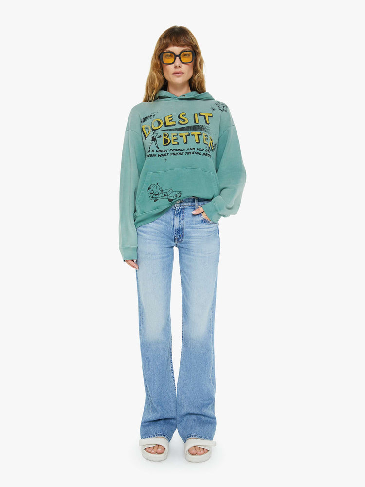 WOMEN full body view of an teal oversized hoodie with drop shoulders, ribbed hems and a front patch pocket and colorful text, doodles, and fading at the shoulders.