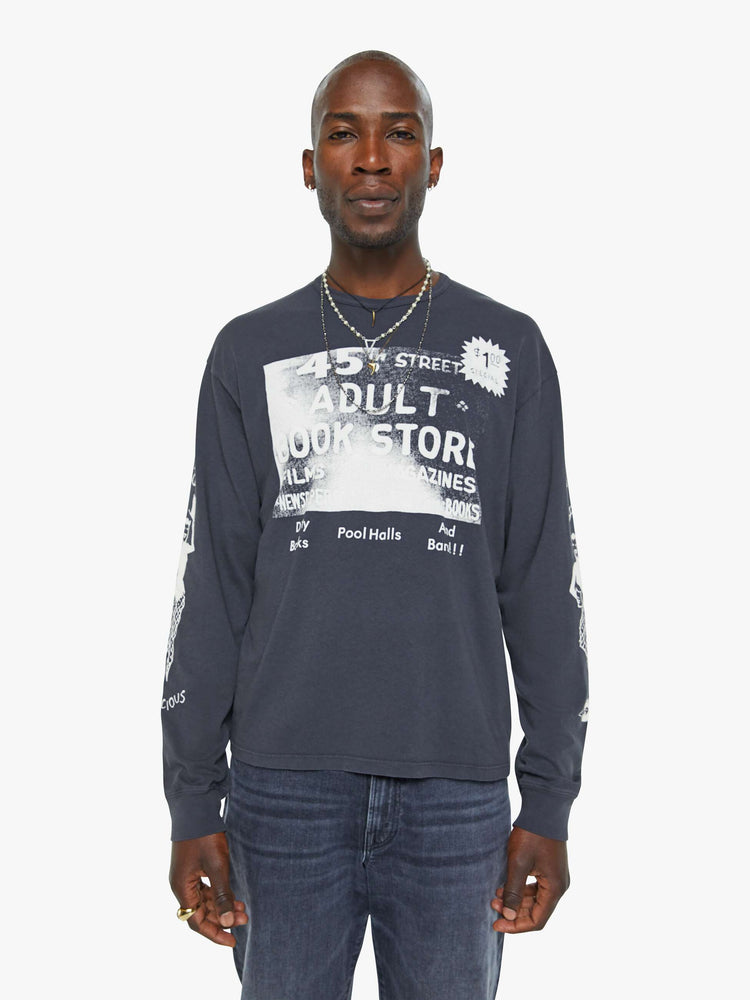 Front view of a man  oversized long sleeve tee with drop shoulders and a loose fit in a faded black with an advertisement in white on the front.