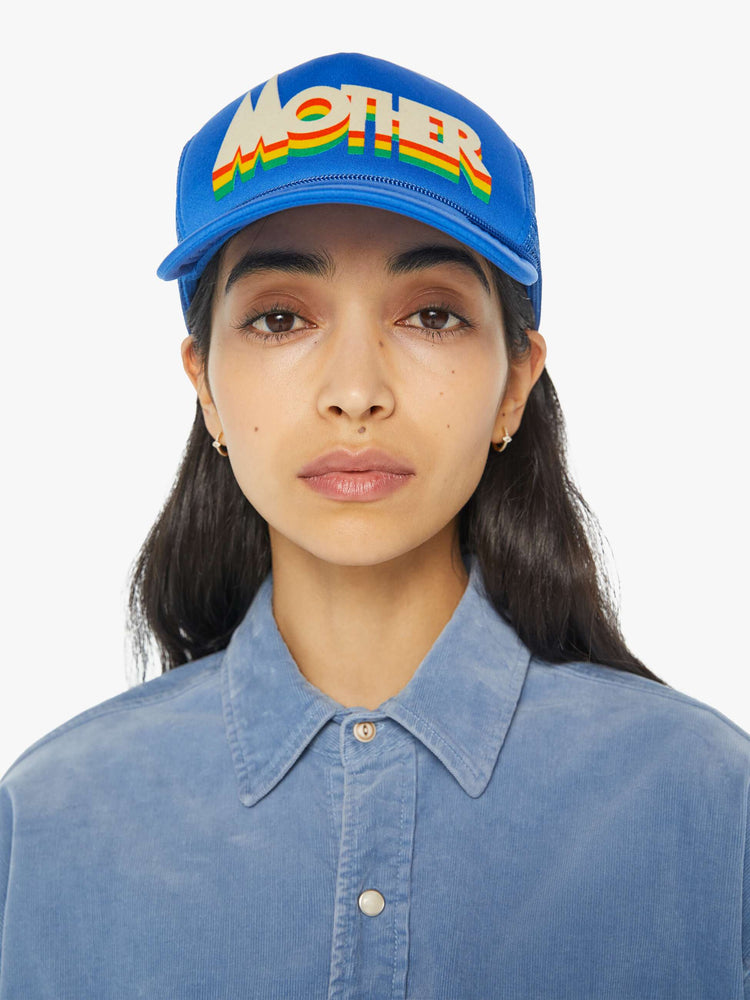 Front view of a vintage-inspired trucker hat designed in blue with MOTHER's name on the front on a model.