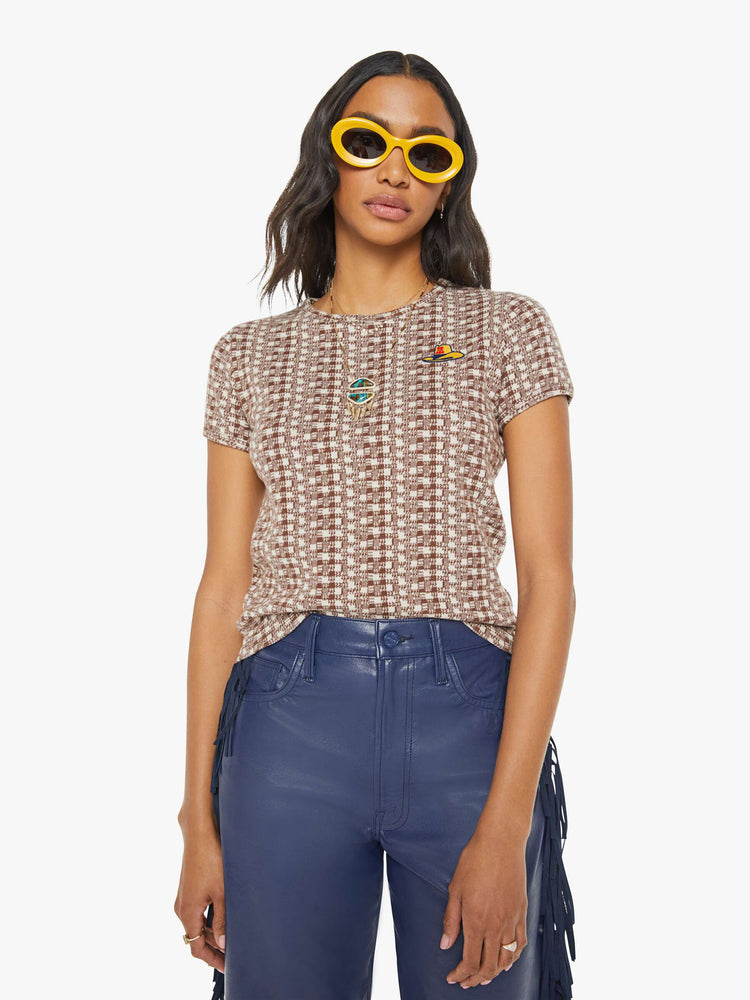 Front view of a woman in cream and brown checkered print with an embroidered cowboy hat tee.