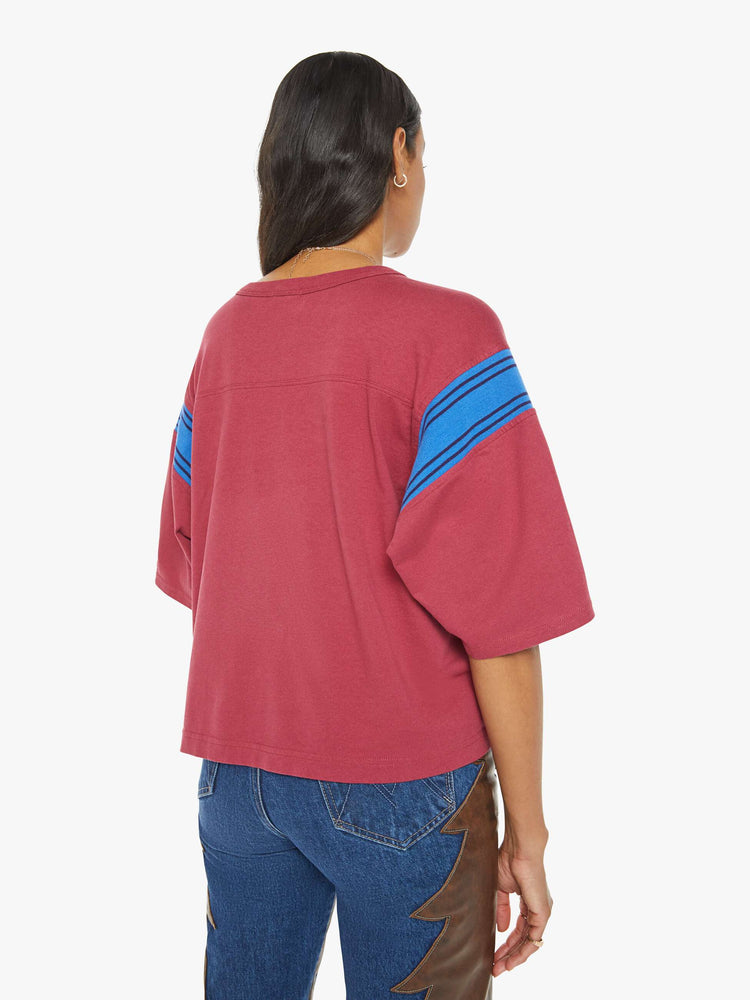 Back view of a faded red vintage-inspired athletic tee with a V-neck, drop shoulders and short boxy sleeves.
