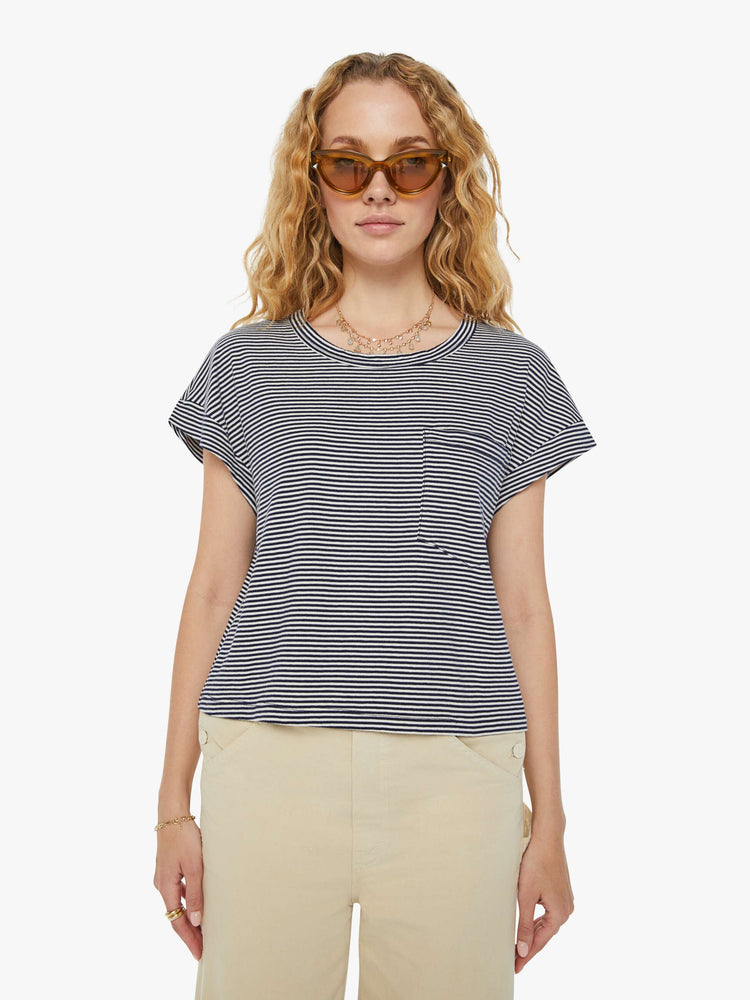 Front view of a woman in a nautical white and navy striped cropped crewneck tee with short rolled sleeves, a chest pocket and a boxy fit. 