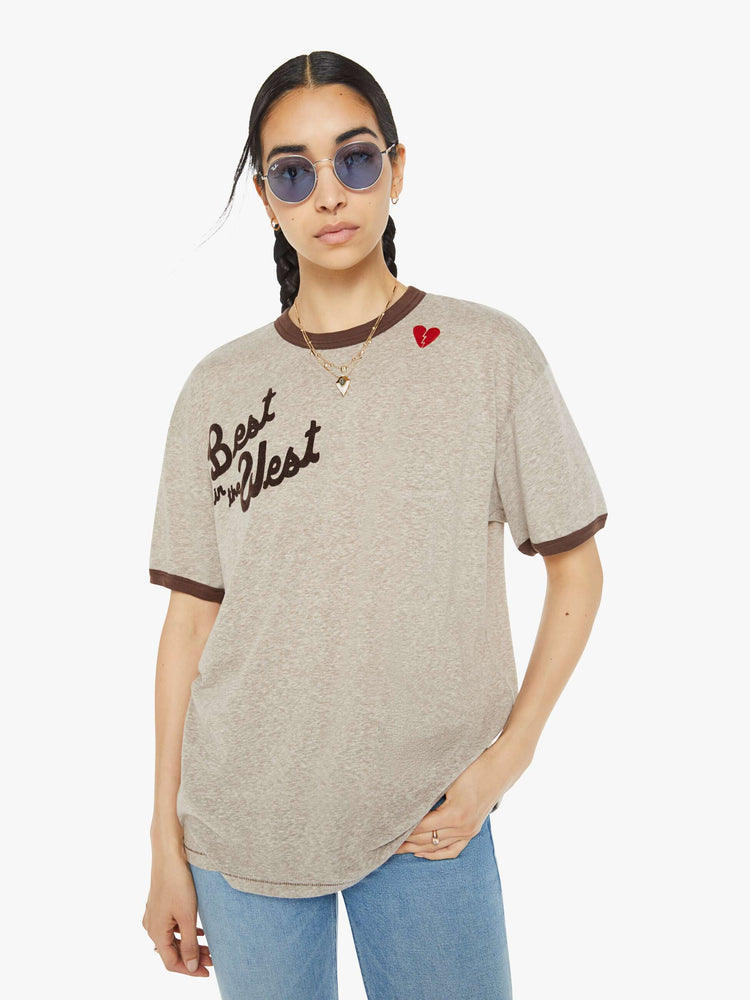 Front view of a woman marled tan oversized tee with drop shoulders and a loose fit with a red heart near the collar.