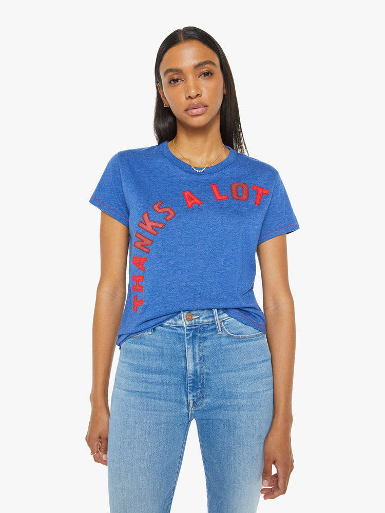 Front view of a woman in a blue tee with mix-matched red patchwork letters on the front that read "Thanks A Lot."