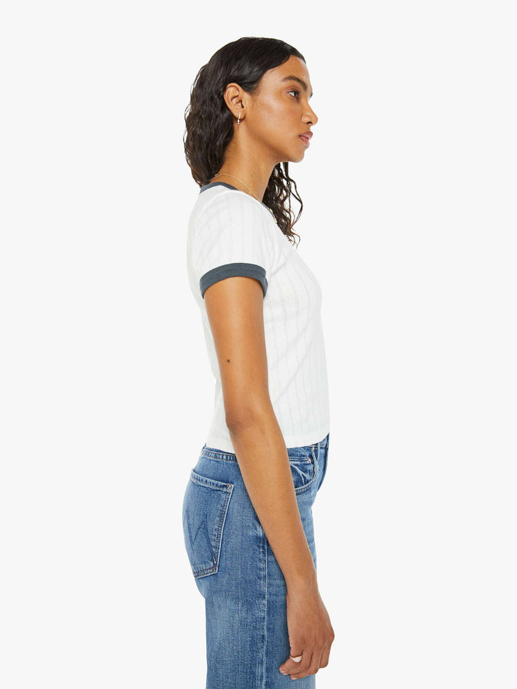 Side view of a women in a white with navy trim shrunken crewneck tee with extra-short sleeves and a cropped hem.