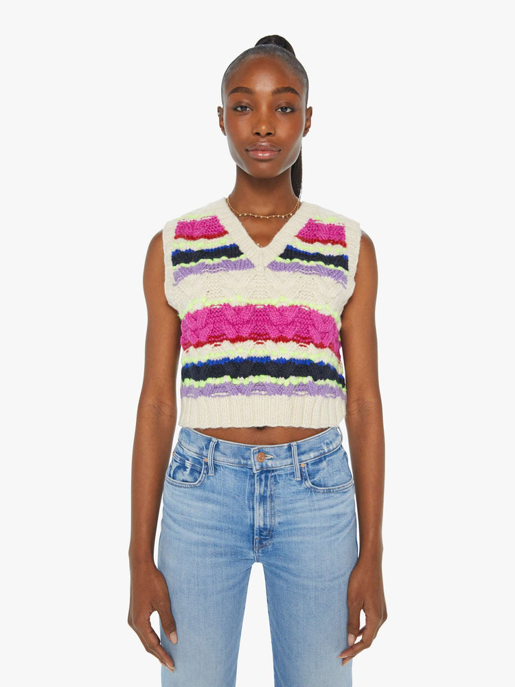 Front view of a woman in a knit sleeveless top with a V-neck and a cropped, ribbed hem in a horizontal stripe pattern with textured knit details.