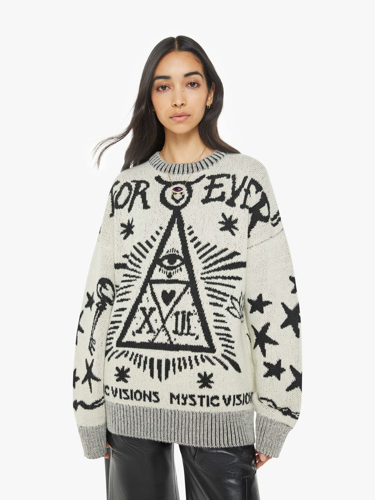 Front view of a woman in a crewneck sweater in a heathered grey with mystic graphics and text in black.