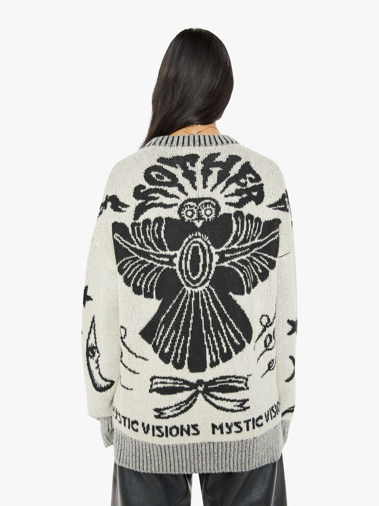 Back view of a woman in a crewneck sweater in a heathered grey with mystic graphics and text in black.