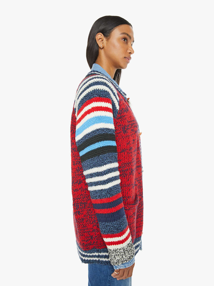 Side view of a woman in an  oversized raglan cardigan with patch pockets, long balloon sleeves and ribbed hems in a marled red and navy knit with striped details and vintage-inspired wooden buttons. 