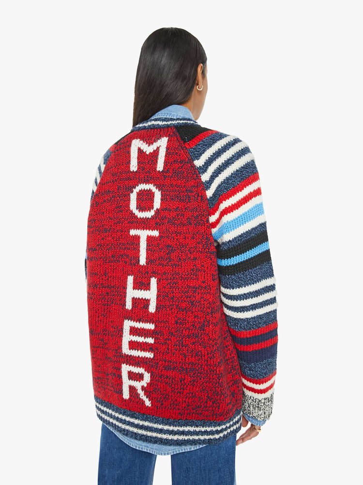 Back view of a woman in an  oversized raglan cardigan with patch pockets, long balloon sleeves and ribbed hems in a marled red and navy knit with striped details and vintage-inspired wooden buttons. 