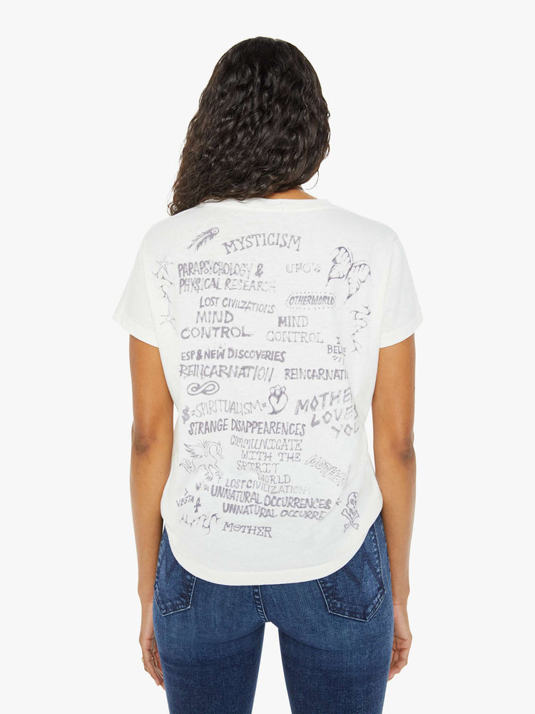 Back view of a woman in a white crewneck with  a faded apple graphic with text in black on the front.