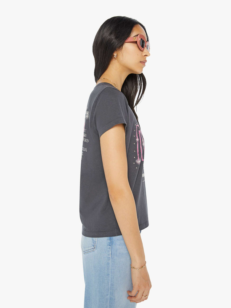 Side view of a woman in a dark grey tee with a merch-inspired graphic on the front and back with rhinestones and studs throughout.