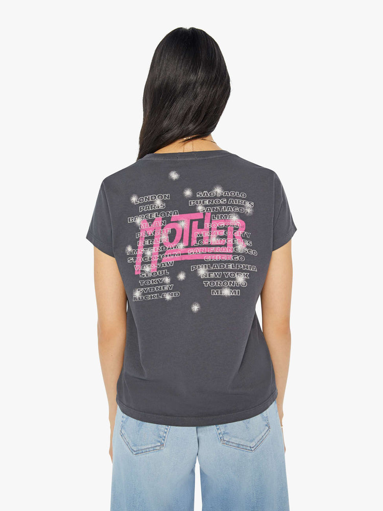 Back view of a woman in a dark grey tee with a merch-inspired graphic on the front and back with rhinestones and studs throughout.