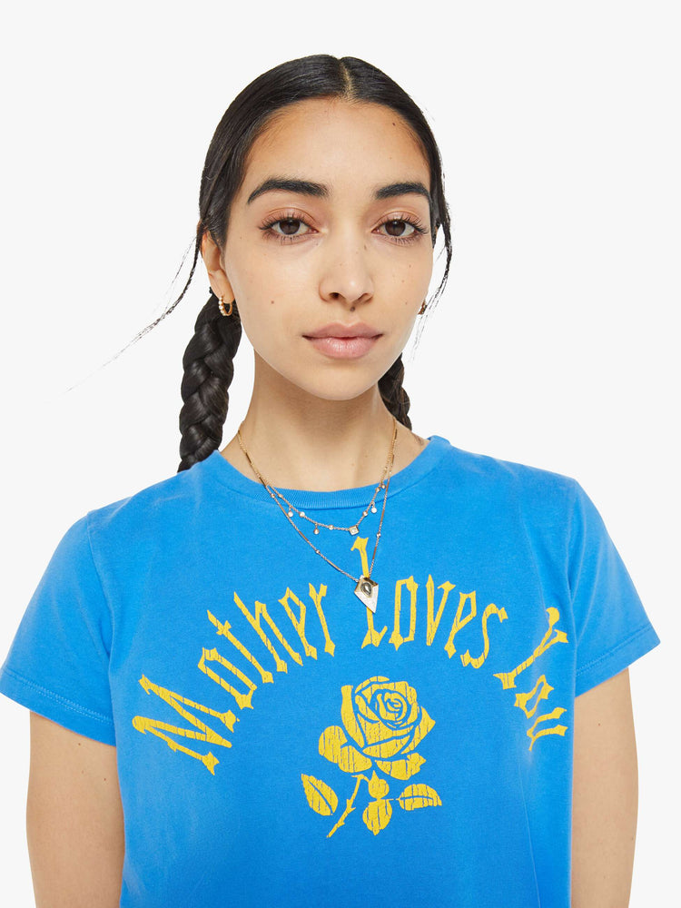 Close up view of a woman blue tee with a message from MOTHER and a yellow rose on the front.