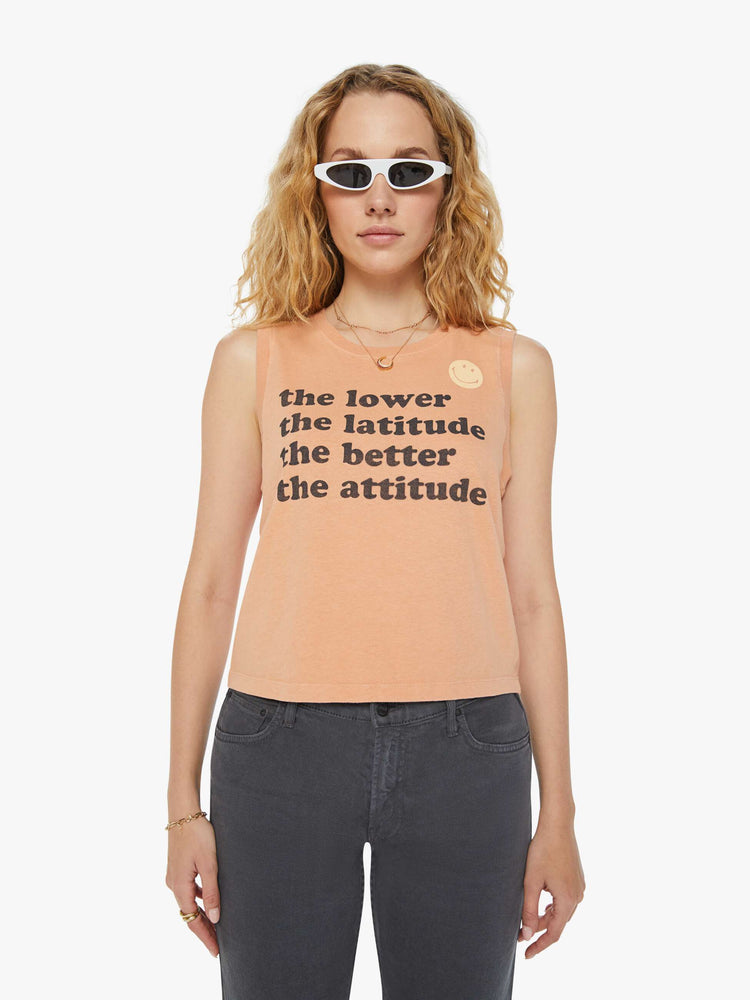 Front view of a woman faded orange tank with a smiley face view of a woman in a colorful desert cactus graphic cropped muscle tee with a crewneck and boxy fit.