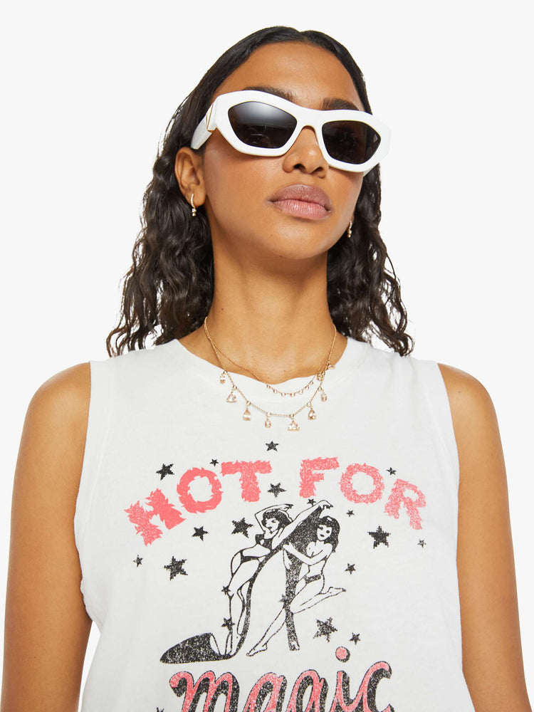 Close up view of a woman in a white with black and pink graphic and text cropped muscle tee with a crewneck and boxy fit.