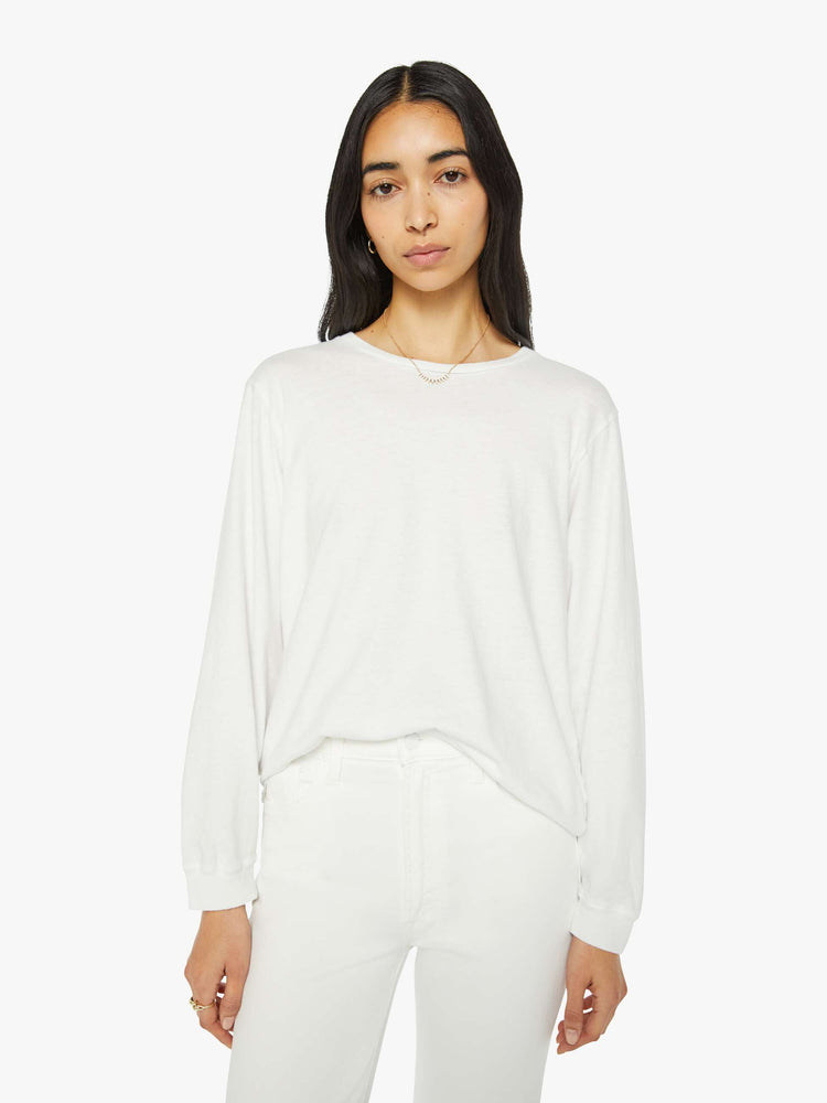 Front view of a woman crewneck tee with long sleeves and an oversized fit in a bight white hue.