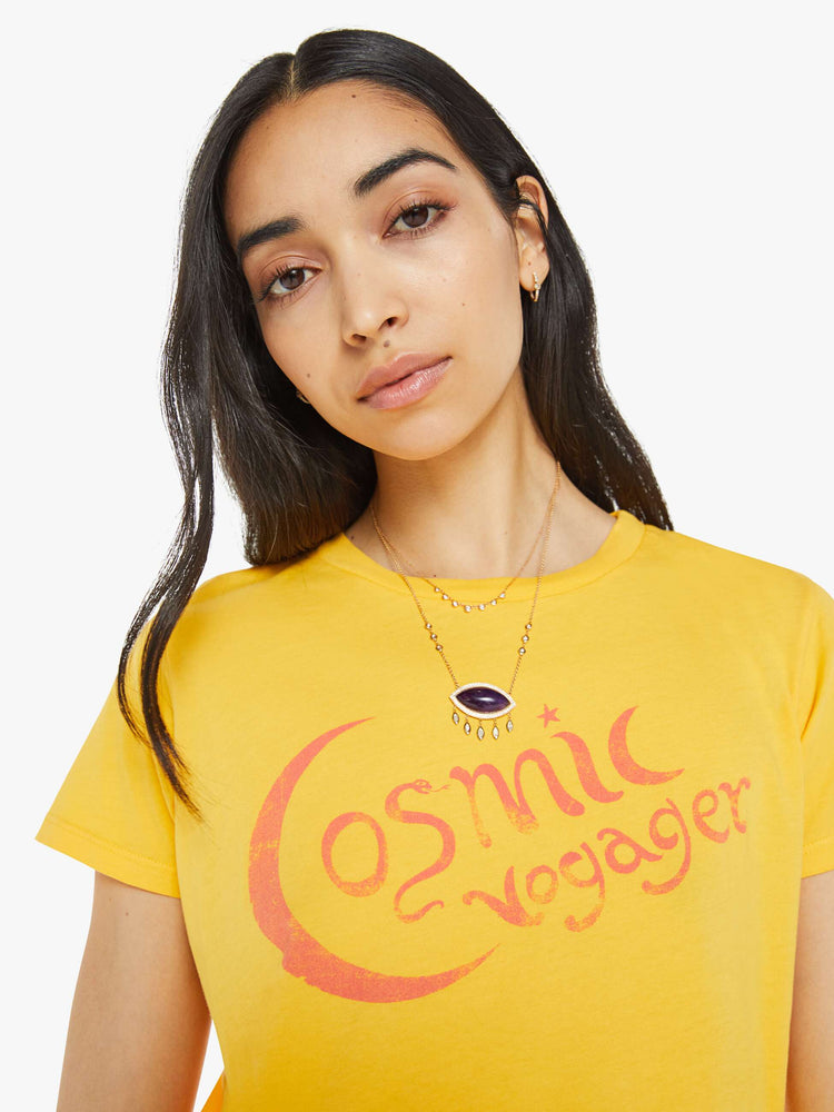 Close up  view of a woman in a yellow tee with orange graphic on the front.