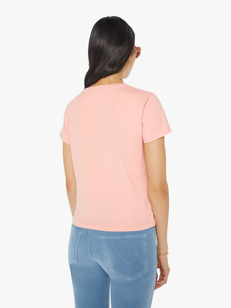 Back view of a woman in a sheer baby pink crewneck tee with a slim fit featuring a faded text graphic on the front.
