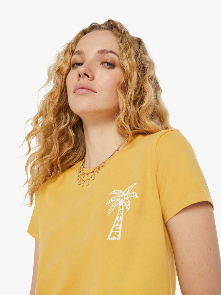 Detailed view of a woman in a yellow slightly sheer slim fit crewneck with a palm tree graphic and MOTHER's name on the chest and back.