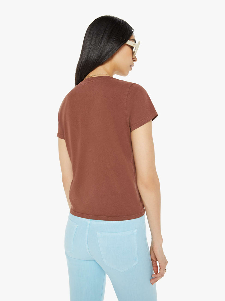 Back view of a woman in faded brown with pink text on a slightly sheer crewneck tee.