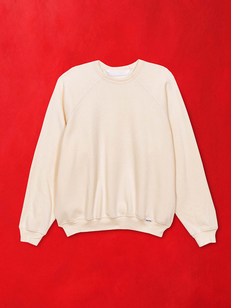 A flat image of an off white sweatshirt against a red background.