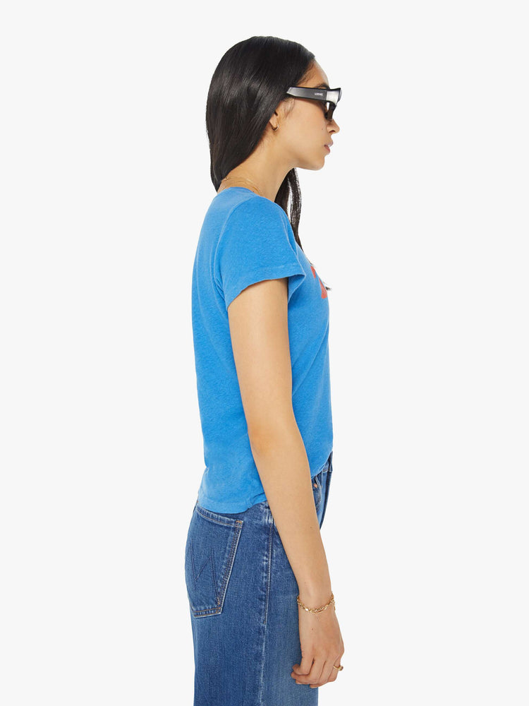 Side view of a woman in a blue tee with a a subtle message from MOTHER in red on the front.