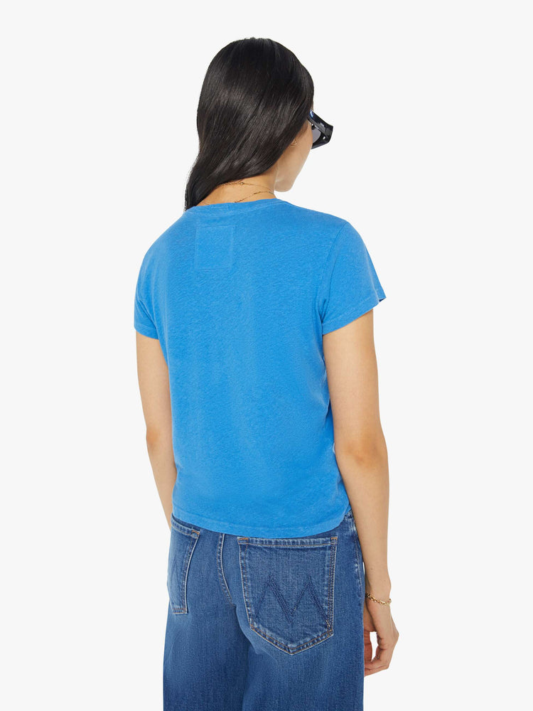 Back view of a woman in a blue tee with a a subtle message from MOTHER in red on the front.