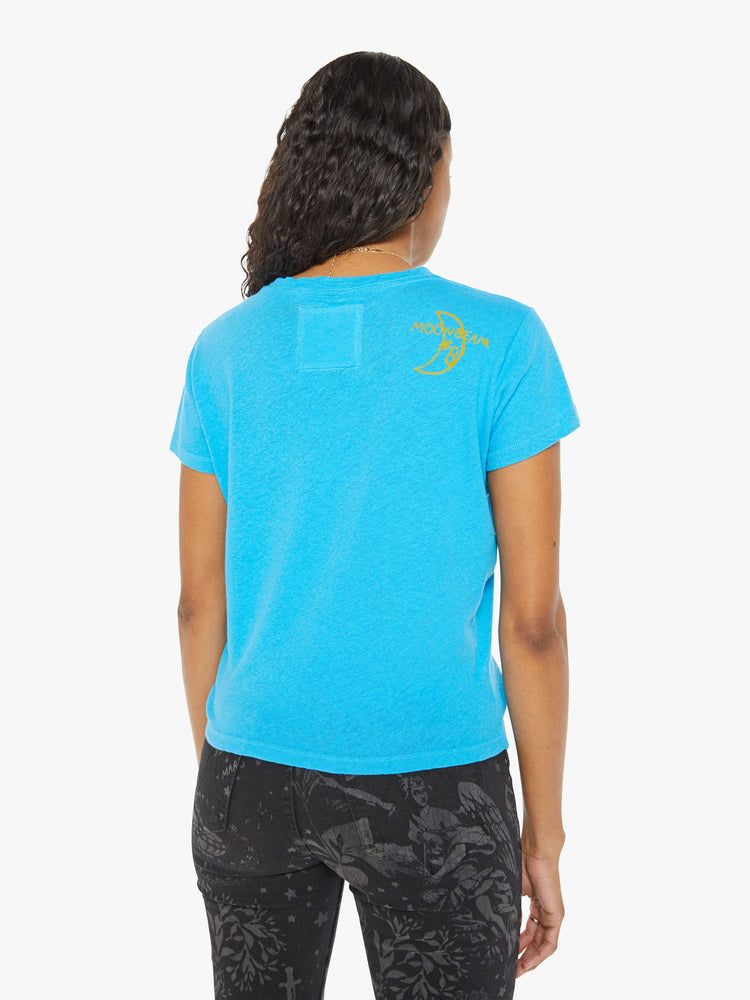 Back view of a woman in a bright blue with a yellow bat graphic with text in black on the front.