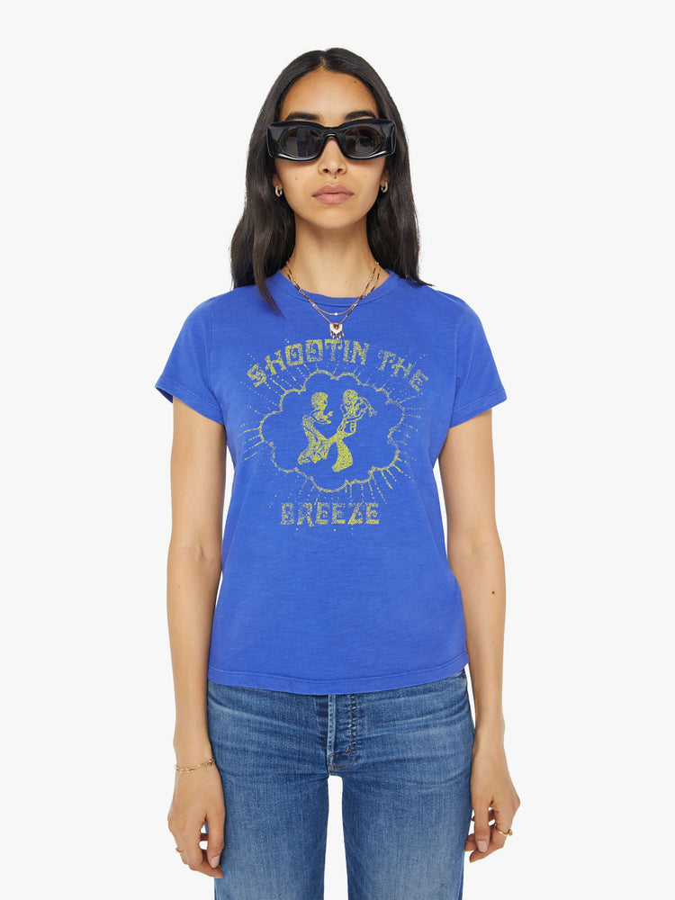 Front view of a woman in a blue crewneck tee with a faded graphic with text in yellow on the front.