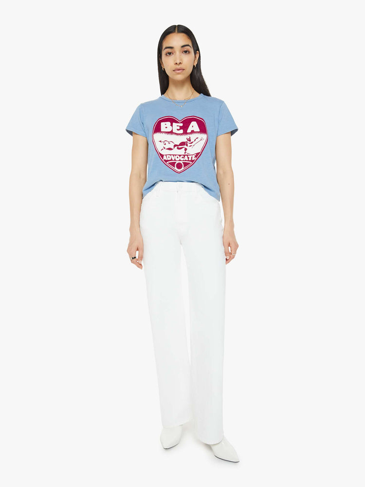 Full body view of a woman in a sky blue color tee with a maroon heart graphic with text on the front.