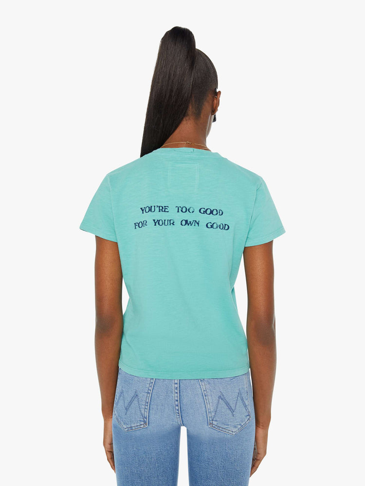 Back view of a woman in a teal tee that features a faded graphic inspired by a fortune teller advertisement on the front and text on the back.