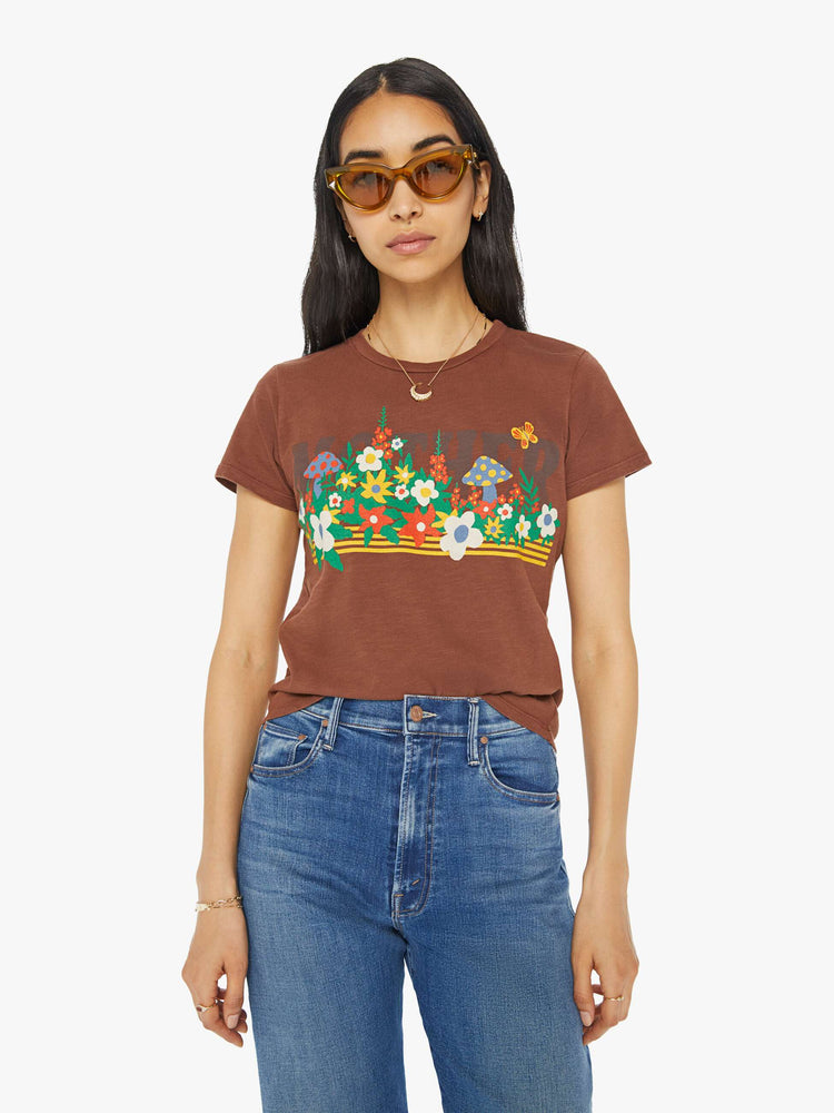 Front view of a woman in a brown crewneck tee with a slim fit featuring a colorful garden bed graphic on the front.