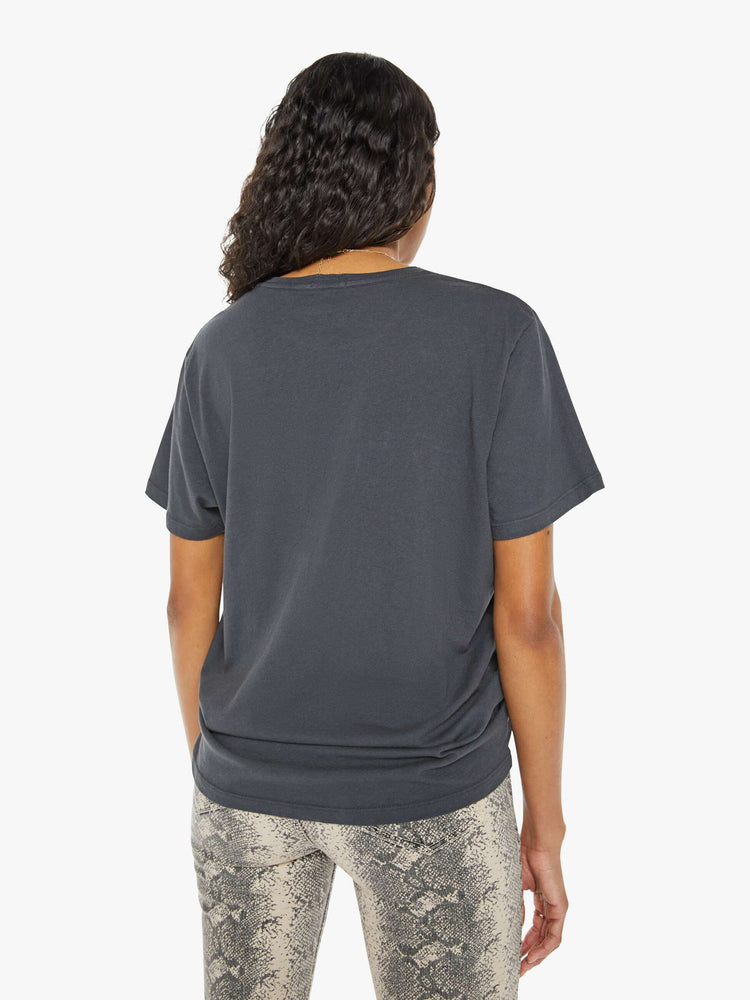 Back view of a woman in a black tee with a golden yellow graphic and MOTHER's name on the front.